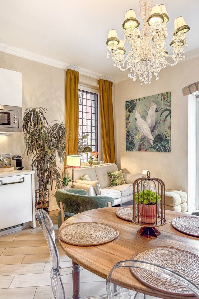 Living and dining area at Santo Stefano with a crystal chandelier, round wooden table and clear chairs